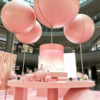 Kiosque de beauté pastel ludique,cabine de cosmétiques à thème avec des installations de boule rose géantes et l'image de marque