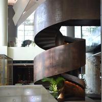 Escalier en colimaçon sur mesure pour loft design avec structure en acier noir et marches en chêne naturel
