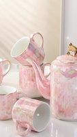 Elegante tetera de cerámica y 6 tazas de té con un mango de color dorado y una tapa con un acabado brillante iridiscente