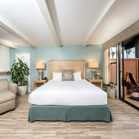 Ensemble de mobilier de chambre d'hôtel moderne pour complexe balnéaire : Lit avec tête de lit en bois blanc vieilli, Table de chevet, Fauteuil en tissu, Ottoman