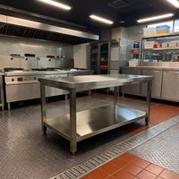 Table de préparation alimentaire en acier inoxydable à pieds carrés de 50 pouces, idéale pour une utilisation commerciale dans les établissements de restauration.