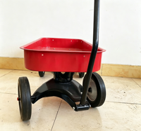 Chariot robuste en acier rouge avec roues tout-terrain lisses, idéal pour le camping, le jardinage et les sorties en plein air pour les enfants.