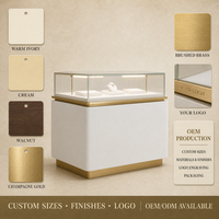 Présentoir à bijoux personnalisé avec éclairage LED, vitrine en verre, corps crème, base or brossé, vente en gros pour les bijouteries
