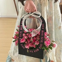 Panier à fleurs en carton noir mat découpé avec poignée ronde, impression « Just For You », ruban rose transparent, nœud, boîte pour bouquet de roses