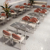 Café à manger ensemble de meubles de café chaises à structure en métal argenté avec siège blanc et dossiers orange avec tables en acier inoxydable