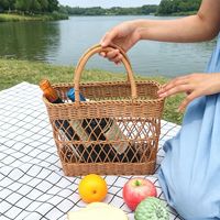 Moderne ecovriendelijke katoenen touwen mand met opengewerkt geweven dessin en handvat voor boodschappen, opbergen, picknick, kamperen en buitengebruik.