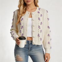 Cardigan court en maille torsadée pour femme, col rond, orné de perles en forme de pétale violettes, par le fabricant Cream Cable