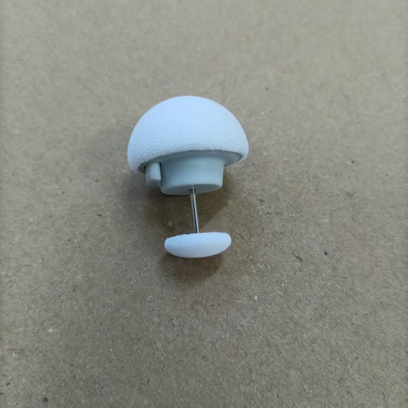Bouton blanc en forme de champignon avec une seule épingle à coudre en tissu.