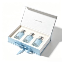 Boîte à parfum bleue de luxe haut de gamme avec logo personnalisé, ruban, doublure en éponge scintillante, emballage rigide en carton magnétique pour 3 flacons