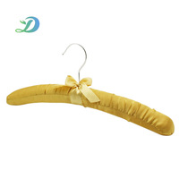 Cintre rembourré en satin jaune doré avec nœud décoratif et crochet argenté pour le rangement des robes en soie dans les chambres d'hôtel