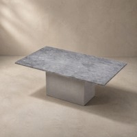 Table basse contemporaine en pierre gris clair avec base moderne en ciment, personnalisable pour les projets hôteliers et de villas