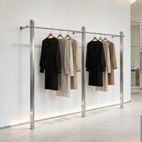 Présentoir mural de luxe léger en acier inoxydable brossé pour vêtements et robes de mariée, idéal pour les magasins de prêt-à-porter féminin