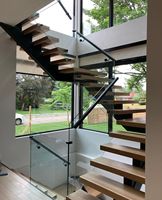 Escalier flottant sur mesure à poutre unique pour villa, avec balustrade en verre trempé