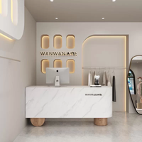 Bureau de réception minimaliste moderne personnalisé en MDF laqué avec éclairage LED et base en bois octogonale pour clinique de beauté