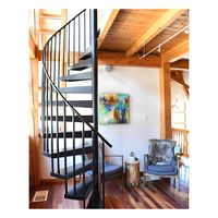 Escalier en colimaçon élégant avec balustrade en fer forgé et main courante en bois poli pour hall de villa de luxe