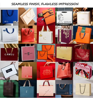 Sac shopping personnalisé en papier métallisé argenté avec logo noir et larges poignées en ruban de satin noir pour vêtements de luxe