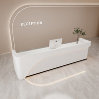 Bureau d'accueil incurvé minimaliste sur mesure avec panneau frontal ondulé cannelé et éclairage LED pour salon de beauté, spa, boutique de vêtements