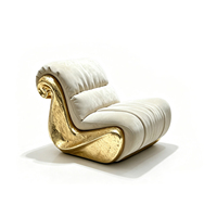 Canapé individuel de designer haut de gamme avec cadre sculptural doré et revêtement gris clair effet nuage pour la décoration intérieure