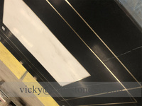 Ascenseur de luxe avec motifs gravés au jet d'eau sur marbre noir Marquina et blanc, et bandes en cuivre et laiton intégrées