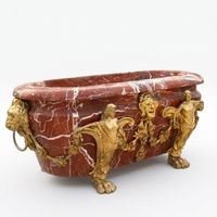 Baignoire autoportante ovale en marbre rouge avec veines blanches, pieds sculptés en forme de sirène et tête de lion dorée, luxe pour hôtel