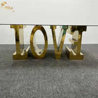 Table de salle à manger NIKA de luxe avec lettres dorées brillantes LOVE, structure en acier inoxydable et plateau en verre, idéale pour les mariages, les événements et les fêtes