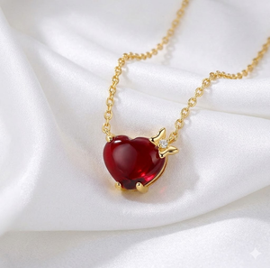 Ornement de cou élégant et romantique plaqué or, orné d'un pendentif en forme de cœur rouge vif avec un ruban doré délicat sur le côté. - Product Image 1