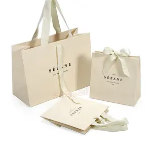 Bolsa de regalo de embalaje de ropa de marfil reciclado personalizado con asa de cinta bolsas de papel de compras de color beige crema de lujo con su propio logotipo