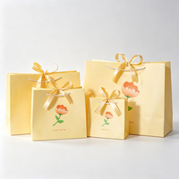 Sac cadeau en papier sulfurisé motif art floral à pétales verts et feuille verte, avec nœud en satin, logo personnalisé, vente en gros