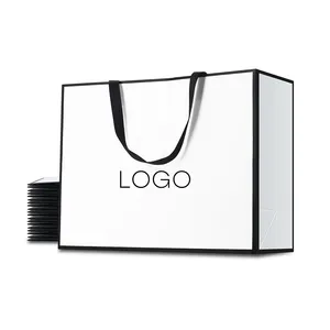 Venta al por mayor de cartón con logotipo personalizado, compras de lujo, joyería, ropa, bolsa de papel para cosméticos, bolsas de regalo blancas, embalaje con marco negro