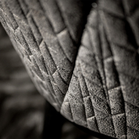 Fauteuil moderne de luxe gris texturé avec dossier incurvé, motif diamant, pieds noirs et embouts dorés, chaise de salle à manger