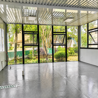 Serre en verre préfabriquée, pièce de jardin modulaire avec structure en acier et murs vitrés pour usage extérieur