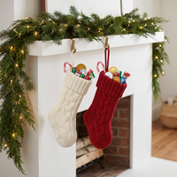 En gros, petits chaussons de Noël rouges et ivoire, ornements tricotés classiques pour bonbons et cadeaux d'enfants