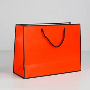 حقيبة فاخرة مخصصة لتجزئة الملابس حقيبة تعبئة وردية اللون للهدايا حقيبة ورقية للتسوق لتعبئة الملابس حقيبة مخصصة بشعار مطبوع