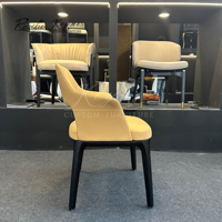 Fauteuil d'appoint contemporain unique à dossier ouvert en similicuir avec accoudoirs à oreilles, structure en bois noir pour café commercial