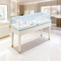 Comptoir de consultation de luxe pour bijouterie, unité d'exposition élégante blanc laiteux et bleu clair avec motif géométrique diamanté pour boutique haut de gamme