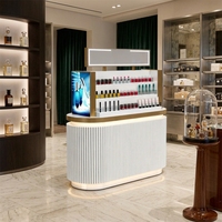 Îlot de présentation de parfums de luxe moderne avec éclairage LED, en MDF et acier inoxydable, base cannelée noire, taille et couleur personnalisables pour le haut de gamme