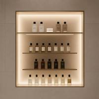 Meuble de présentation cosmétique incurvé moderne sur mesure, comptoir îlot en métal pour parfums, vitrine murale LED pour magasin de beauté de luxe