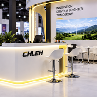 Stand d'exposition modulaire 20x20 pieds avec enseigne suspendue circulaire, structure tubulaire en arche et comptoir lumineux pour l'Expo DesignCon 2027