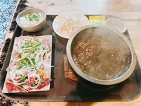 Bibimbap coréen, riz mélangé, dolsot, pot en aluminium enveloppé de papier d'aluminium, bol en pierre avec assiette en bois
