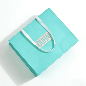 Sac en papier rigide vert menthe doux avec poignée en ruban satiné et logo central pour l'emballage de gants, mitaines et accessoires de mode - Product Image 1