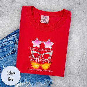 Camiseta de Mujer Comfort Colors, Roja, Cuello Redondo, Manga Corta, 100% Algodón, Estampado 'Strength Looks Different' para el Día Internacional de la Mujer - Product Image 3