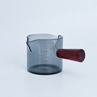 Vaso medidor de vidrio verde de 75 ml / 2.2 oz con un solo mango de madera para extractos de sabor, alimentos, concentrados de café y bebidas espirituosas.