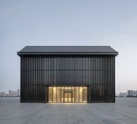 Edificio Comercial Prefabricado de Estructura de Acero con Rejillas Metálicas Verticales y Entrada de Vidrio