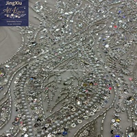 Tissu en dentelle brodée de perles et de sequins en cristal argenté sur maille avec bord festonné pour robe de mariée ou de soirée