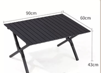 Table de camping en aluminium avec pieds renforcés et antidérapants, facile à installer, stable sur les surfaces en herbe et en gravier.