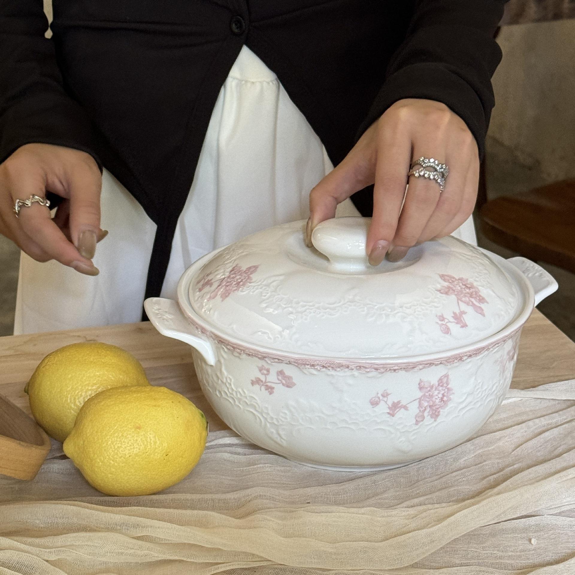 A bowl of imperial pink flower soup with a lid