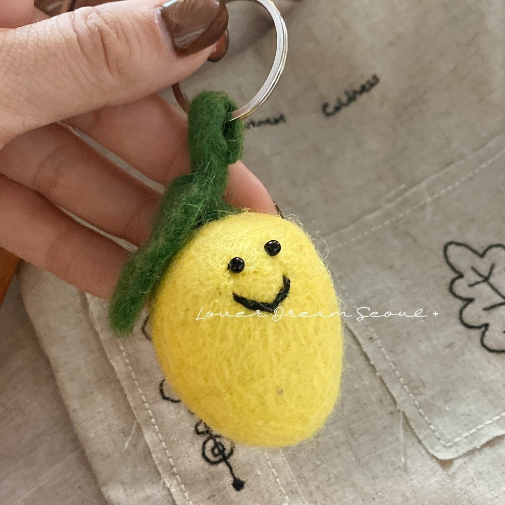 Ciondolo in feltro di lana con faccina sorridente al limone