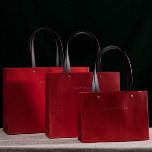 ถุงกระดาษสีแดงหรูหราแบบกำหนดเองพร้อมหูหิ้วหนัง โครงสร้างแข็งแรง ปั๊มโลโก้ด้วยความร้อน สำหรับบรรจุภัณฑ์ของขวัญและขายปลีก - Product Image 1
