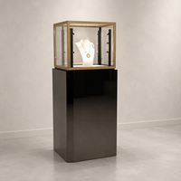 Vitrine de présentation de bijoux de luxe en verre avec éclairage LED, finition dorée, moulures étagées et base polie foncée pour boutique