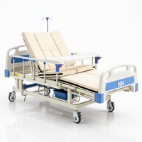Lit de soins à chevet avec roulettes pivotantes, bac de rinçage, plateau à shampoing et canalisation des lignes urinaires pour l'angle de la baie de soins des patients
